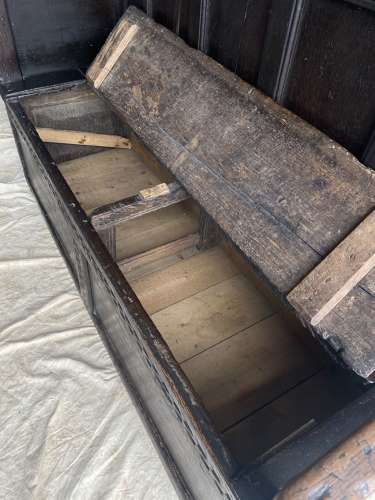 An antique and uncommon 17th century carved oak tavern box settle