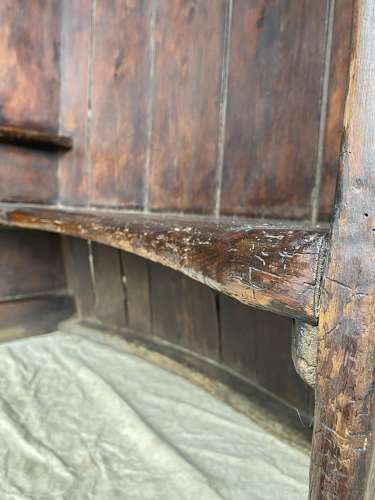 An antique George III pine barrel back tavern settle