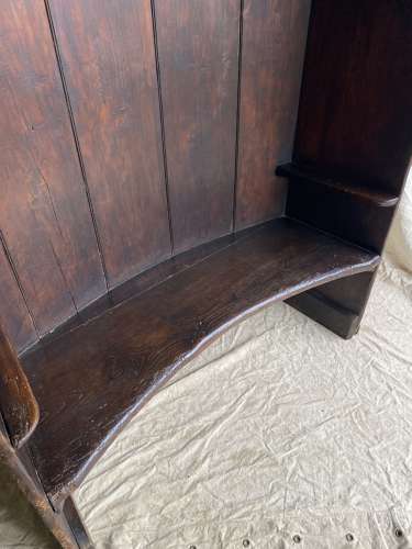 An antique George III pine barrel back tavern settle