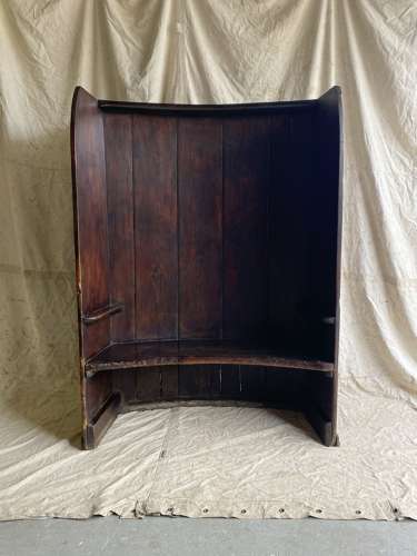 An antique George III pine barrel back tavern settle