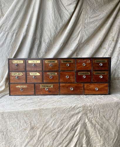 A bank of antique late Victorian apothecary shop drawers