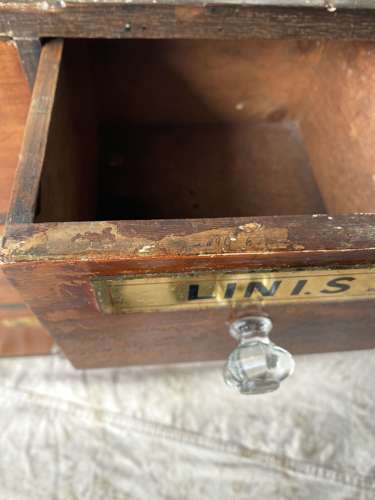 A bank of antique late Victorian apothecary shop drawers