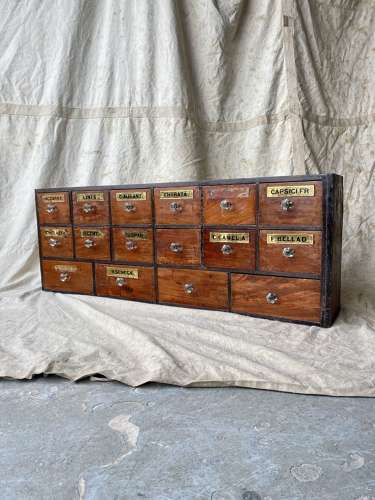 A bank of antique late Victorian apothecary shop drawers
