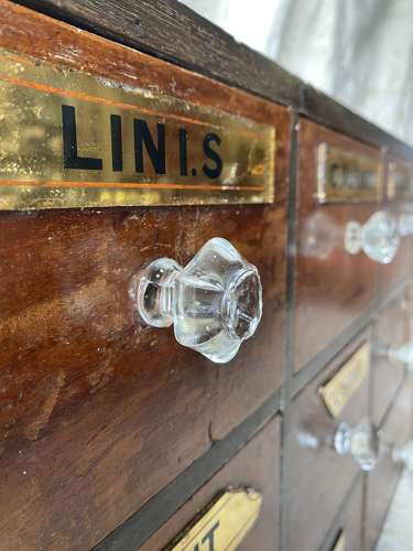 A bank of antique late Victorian apothecary shop drawers