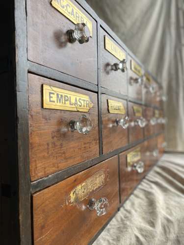 A bank of antique late Victorian apothecary shop drawers