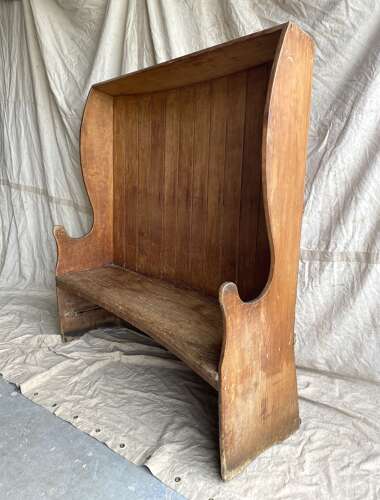 An antique George III pine barrel back tavern settle