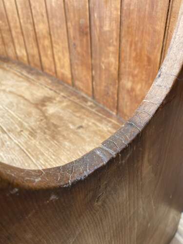 An antique George III pine barrel back tavern settle