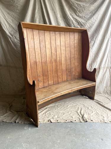 An antique George III pine barrel back tavern settle