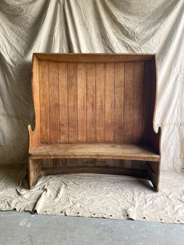 An antique George III pine barrel back tavern settle