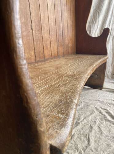 An antique George III pine barrel back tavern settle