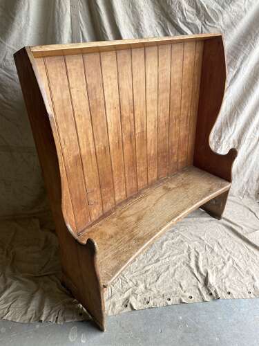 An antique George III pine barrel back tavern settle