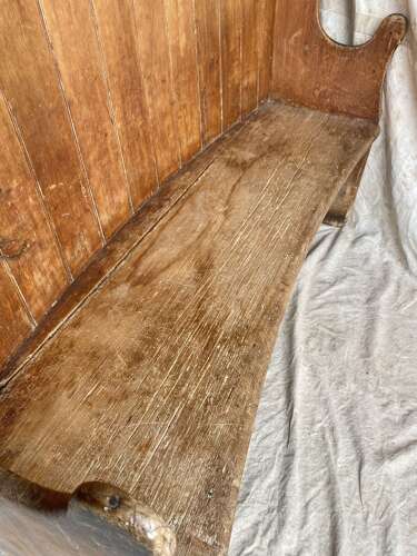 An antique George III pine barrel back tavern settle