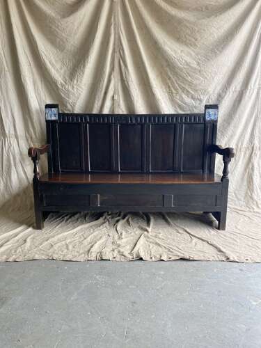 An antique 17th century English oak settle inset with delft tiles