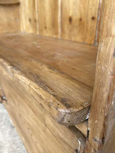 An antique early 19th century West Country pine and elm panel back settle