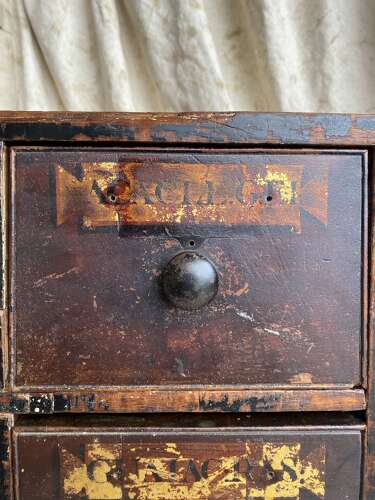 A bank of antique early 19th century mahogany and pine apothecary drawers