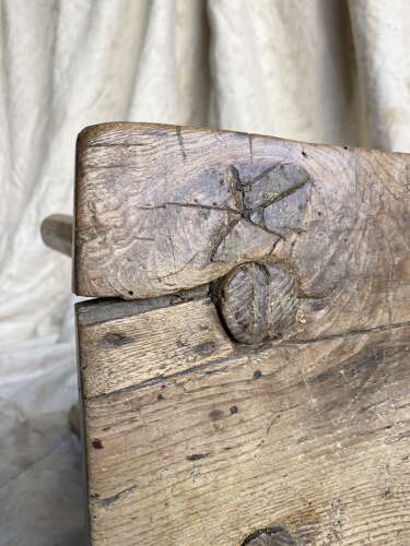 An antique Georgian elm dairy stool with iron strap repair