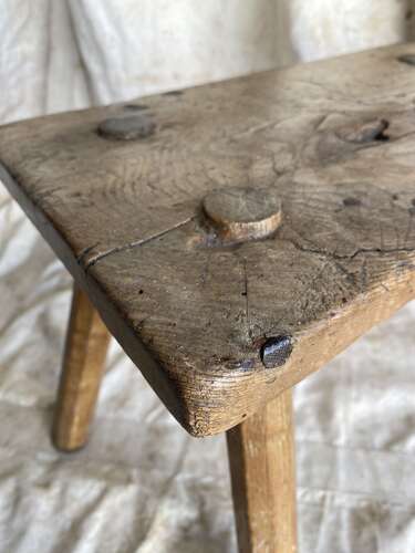 An antique Georgian elm dairy stool with iron strap repair