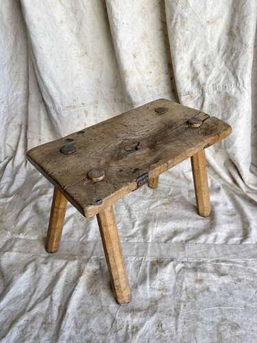 An antique Georgian elm dairy stool with iron strap repair
