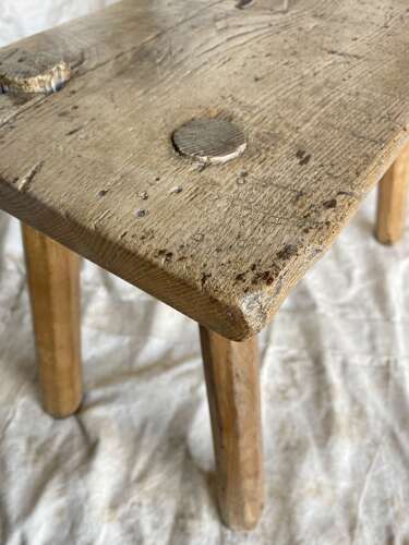 An antique Georgian elm dairy stool with iron strap repair