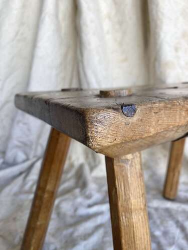An antique Georgian elm dairy stool with iron strap repair