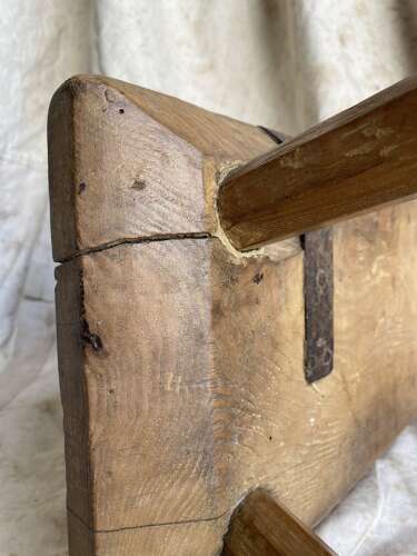 An antique Georgian elm dairy stool with iron strap repair