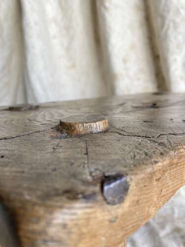An antique Georgian elm dairy stool with iron strap repair