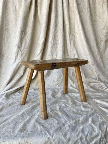 An antique Georgian elm dairy stool with iron strap repair