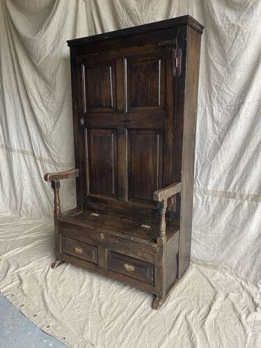 A charming antique English 18th century oak bacon back settle of small proportions