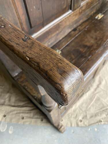 A charming antique English 18th century oak bacon back settle of small proportions