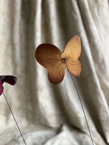 An antique clockwork musical toleware fabric flower and butterfly automaton