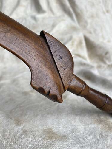 An antique early 19th century folk art fruitwood knitting sheath with apotropaic symbol